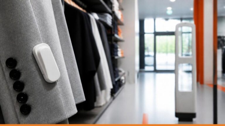 Etichetta antitaccheggio su un capo d'abbigliamento in negozio con varco di sicurezza sullo sfondo